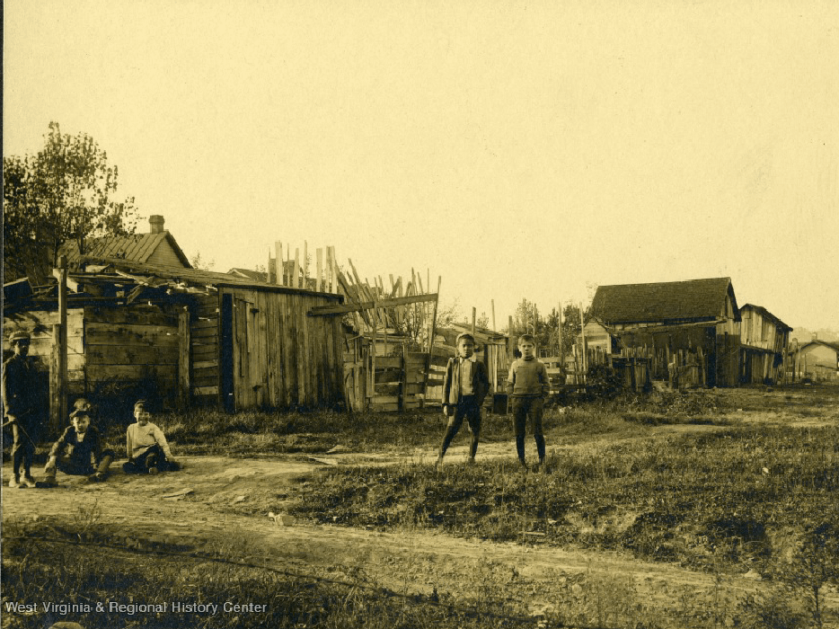 old photo of people standing near old houses